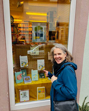 Foto von Sabine vorm Schaufenster eines Buchhandlungsschaufensters mit ihrem Ratgeber "Mein Krisen-Set" darin