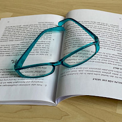 Foto: aufgeschlagener Ratgeber mit Lesebrille