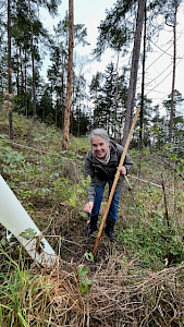 Foto von Sabine mit ihrer ersten selbst gepflanzten Eiche im Thüringer Wald