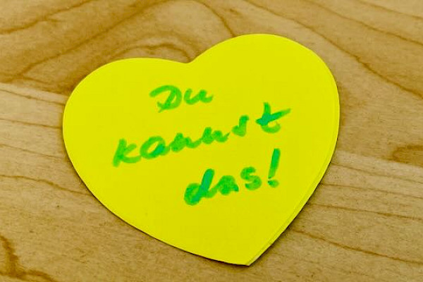 Gelbes Papierherz mit der Aufschrift "Du kannst das!" für Motivation im Prüfungs-Survival-Kit