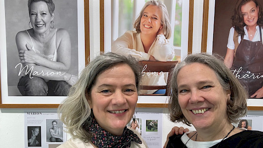 Susan Graul und Sabine Musseleck vor dem Porträt von Sabine in Susans Foto-Ausstellung "50 over 50 STUNNING EDGES" in Regensburg 2026